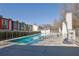 Sparkling community pool featuring clear blue water and a row of modern colorful townhomes in the background at 1412 Peter Haughton Nw Way, Atlanta, GA 30318