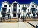 Modern townhome complex featuring white brick, black trim, and well-maintained landscaping for an appealing curb appeal at 518 Healy Dr # 68, Cumming, GA 30040