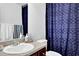 Clean bathroom with a single vanity and navy blue shower curtain at 3945 Silverthorn Trce, Cumming, GA 30028