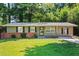 Ranch style home with brick facade, and a well-manicured lawn at 4090 Tara Dr, Forest Park, GA 30297