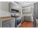 Renovated kitchen with gray cabinets and stainless steel appliances at 4090 Tara Dr, Forest Park, GA 30297