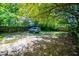 Large backyard with mature trees and gravel parking area at 99 Moreland Se Ave, Atlanta, GA 30316