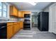 Kitchen with wood cabinets, modern appliances, and vinyl flooring at 99 Moreland Se Ave, Atlanta, GA 30316