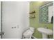 Modern powder room with green walls, a pedestal sink, and stylish shelving at 1187 Rambler Cross, Atlanta, GA 30312