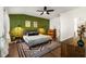 Main bedroom with green accent wall, hardwood floors, and a ceiling fan at 1187 Rambler Cross, Atlanta, GA 30312