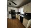 Kitchen boasting white cabinets, black appliances, and a breakfast bar at 1779 Big Horn Se Ct, Conyers, GA 30013