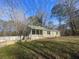 Light green ranch style home with a front porch and a yard at 214 Pinewood Ln, Stockbridge, GA 30281