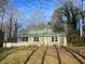 Ranch house with green roof and porch, nestled among tall trees at 214 Pinewood Ln, Stockbridge, GA 30281