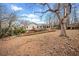 The backyard features a large tree and a wooden ramp leading to the house and deck at 6389 Grafton Dr, Austell, GA 30168