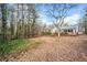 This house features a long wooden ramp leading to the deck, surrounded by trees in the backyard at 6389 Grafton Dr, Austell, GA 30168