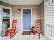 Cozy front porch with red chairs, a welcome mat, and a blue front door at 6389 Grafton Dr, Austell, GA 30168