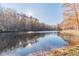 Serene pond surrounded by colorful autumn trees reflecting in the water at 686 Newton Factory Bridge Rd, Covington, GA 30014