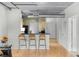 Modern kitchen with light wood cabinets, black appliances, and breakfast bar at 800 Peachtree St # 1112, Atlanta, GA 30308