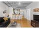 Open living area with hardwood floors, exposed beams, and kitchen bar at 800 Peachtree St # 1112, Atlanta, GA 30308