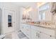 Double vanity bathroom with granite countertops, white cabinets, and marble flooring at 754 Somersby Dr, Dallas, GA 30157