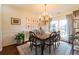 Bright dining room with hardwood floors, large window, and stylish chandelier at 5274 Monarch Pine Ln, Peachtree Corners, GA 30071