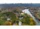 Aerial view of house nestled in autumn foliage, near river and city skyline at 3220 Farmington Se Dr, Atlanta, GA 30339