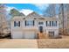 Two-story house with gray siding, two-car garage, and a wooden staircase leading to the front entrance at 66 Trevor Way, Temple, GA 30179