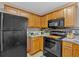 Well-equipped kitchen with black appliances and wood cabinets at 66 Trevor Way, Temple, GA 30179