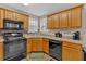 Cozy kitchen corner with wood cabinets and black appliances at 66 Trevor Way, Temple, GA 30179