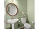 Powder room with pedestal sink, decorative mirror, and green walls at 1772 Benningfield Dr, Marietta, GA 30064