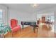 Living room with hardwood floors, piano, and red armchair at 4817 Carlene Sw Way, Lilburn, GA 30047