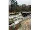 River with rocks and rapids, surrounded by trees at 4817 Carlene Sw Way, Lilburn, GA 30047