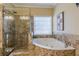 Elegant bathroom with a glass-enclosed shower, soaking tub, and decorative tile at 3639 Fowler Rdg, Douglasville, GA 30135