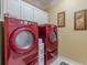 Functional laundry room with red washer and dryer and storage cabinets at 3639 Fowler Rdg, Douglasville, GA 30135