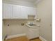 Laundry room with white cabinets, sink, and tile floor at 325 Yellowroot Ln, Sandy Springs, GA 30350