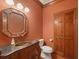 Elegant powder room with dark vanity, copper sink and orange walls at 325 Yellowroot Ln, Sandy Springs, GA 30350