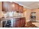 Basement bar with dark wood cabinets, stainless steel accents, and wine cooler at 531 Sweetfern Ln, Sugar Hill, GA 30518