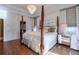 Spacious bedroom with hardwood floors and a large four-poster bed at 531 Sweetfern Ln, Sugar Hill, GA 30518