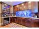 Kitchen wet bar with a large aquarium, wine cooler, and custom cabinetry at 531 Sweetfern Ln, Sugar Hill, GA 30518