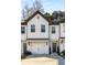 Two-story townhome with white exterior, gray accents, and a two-car garage at 4197 Spring Valley Cir, Tucker, GA 30084