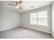 Bedroom with grey carpet, window, and ceiling fan at 9020 Amberly Way, Cumming, GA 30028