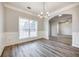 Spacious dining room with hardwood floors, wainscoting, and a chandelier at 9020 Amberly Way, Cumming, GA 30028