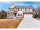 Two-story house with brick and siding, a porch, and a two-car garage at 9020 Amberly Way, Cumming, GA 30028