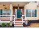 Green front door with a brick entryway and a wooden porch at 9020 Amberly Way, Cumming, GA 30028