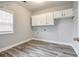 Laundry room with upper cabinets and vinyl flooring at 9020 Amberly Way, Cumming, GA 30028