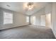 Large main bedroom with grey carpet, high ceiling, and two windows at 9020 Amberly Way, Cumming, GA 30028