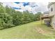 Landscaped backyard with deck and wooded backdrop at 121 Millwheel Dr, Villa Rica, GA 30180