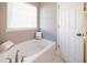 Bathroom with garden tub, neutral walls, and marble-look tile at 2770 Stony Place Ct, Grayson, GA 30017