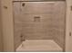 Clean bathroom with a tub and shower, featuring neutral tone tile at 4821 Josie Way, Acworth, GA 30101