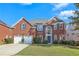 Two-story brick house, two-car garage, lush landscaping at 575 Maple Crest Dr, Lawrenceville, GA 30044