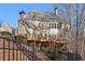 Rear exterior view of the house with multi-level deck and wooded backdrop, with a black fence visible at 335 Boundary Pl, Roswell, GA 30075