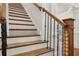 Detailed staircase showcasing hardwood treads, decorative iron railings, and a wooden banister post at 335 Boundary Pl, Roswell, GA 30075