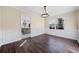 Spacious dining room with chandelier, hardwood floors, and view into kitchen at 1379 Chatley Way, Woodstock, GA 30188