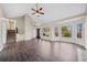 Bright, open living room featuring a ceiling fan, large windows, and wood-look floors at 1379 Chatley Way, Woodstock, GA 30188