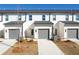 Townhouse exterior with gray garage doors and landscaping at 1641 Winpost Nw Ln, Atlanta, GA 30318